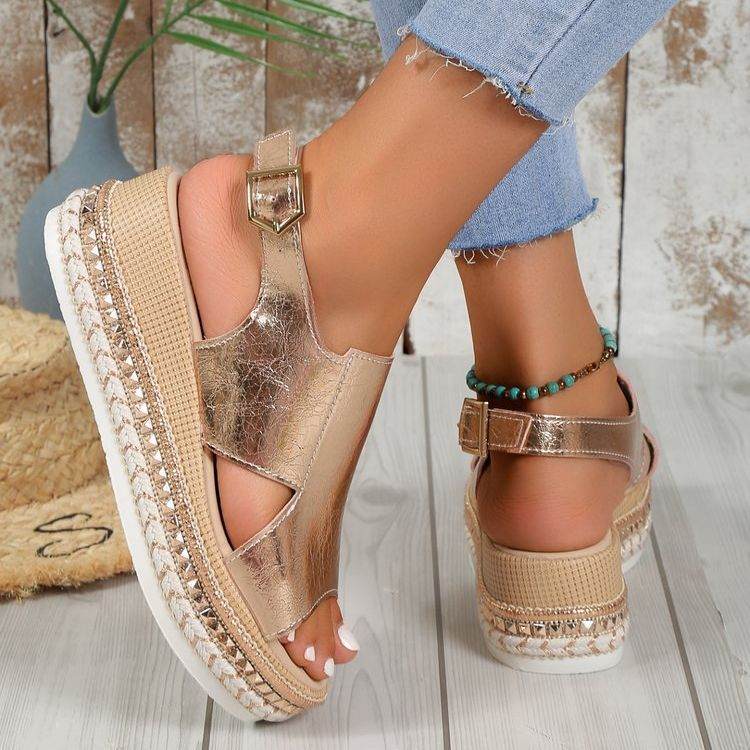 Women wearing shiny gold summer sandals with fish mouth design and buckle wedges on wooden floor