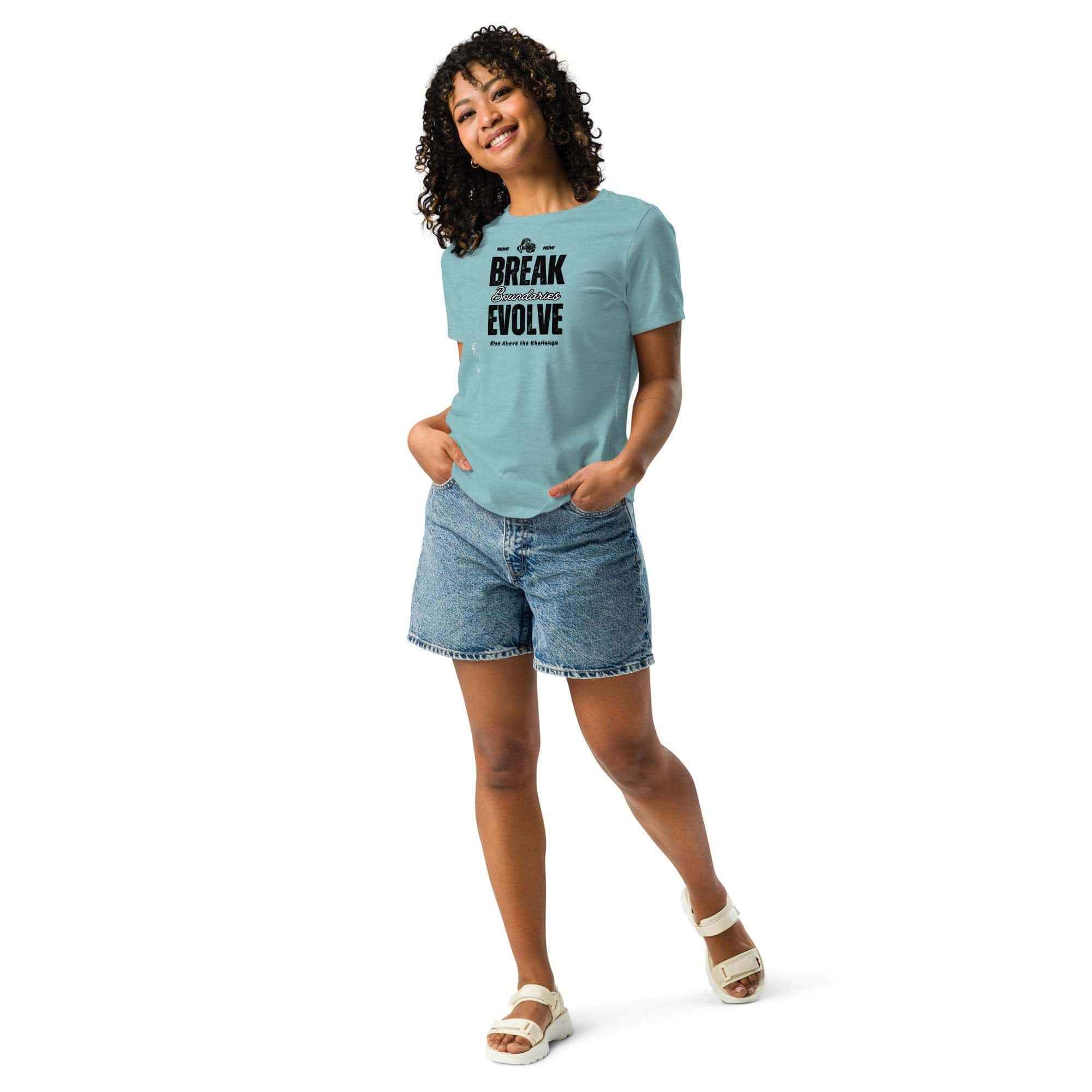 Woman wearing light blue Break Boundaries Evolve T-Shirt with black motivational text, paired with denim shorts and white sandals