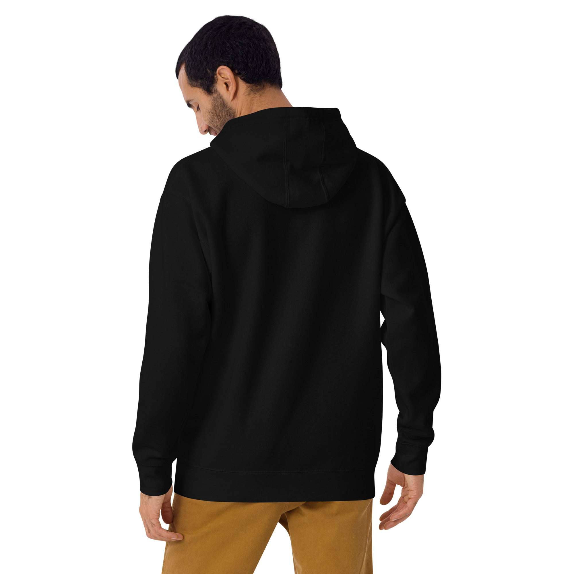 Man wearing black Keep Seeking Growth Hoodie from the back with hood up and brown pants