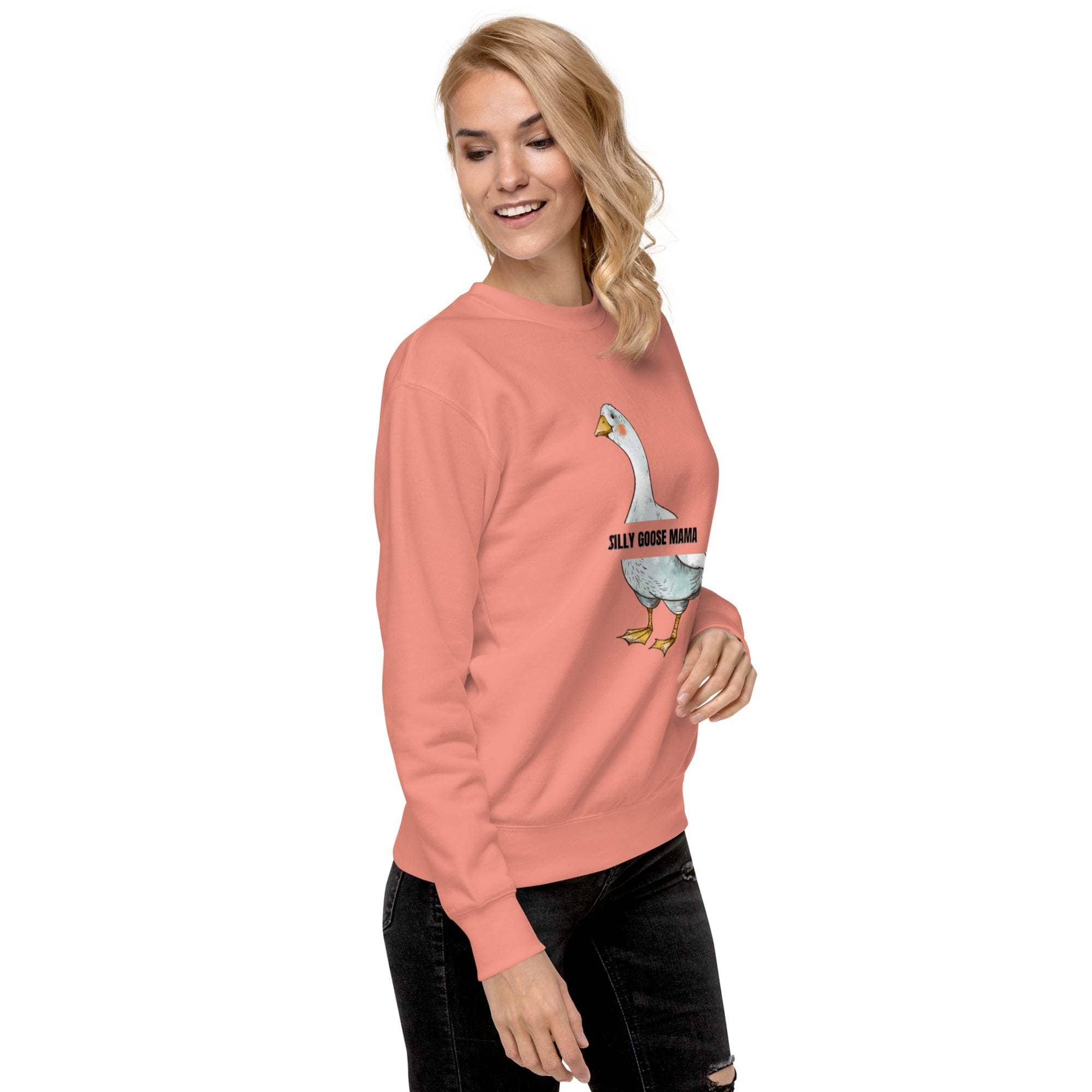 Woman wearing a pink Silly Goose Mama Sweatshirt with a playful goose illustration and text, styled casually with black jeans.