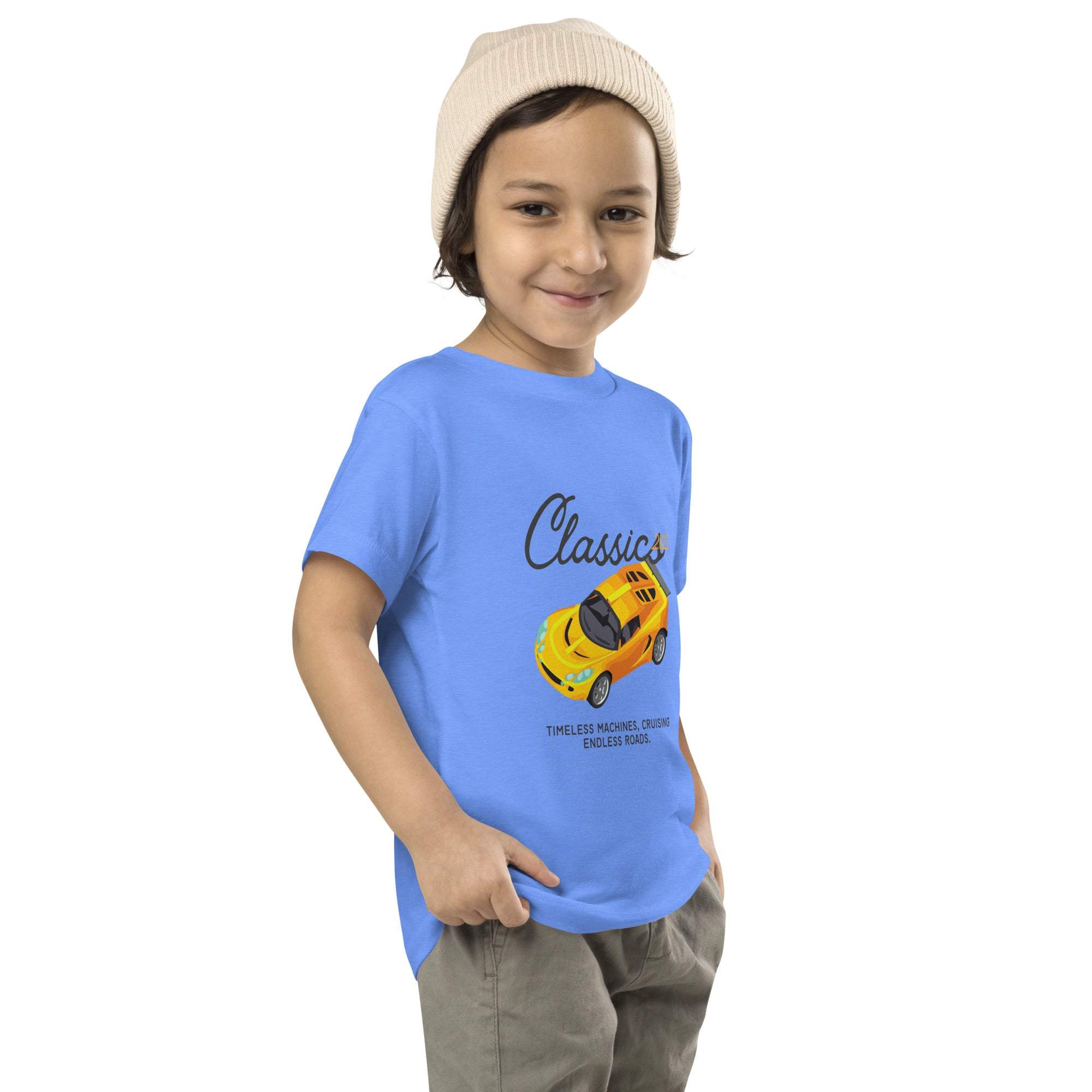 Toddler wearing blue Classic Car Kids T-Shirt with yellow vintage sports car design and beige beanie.