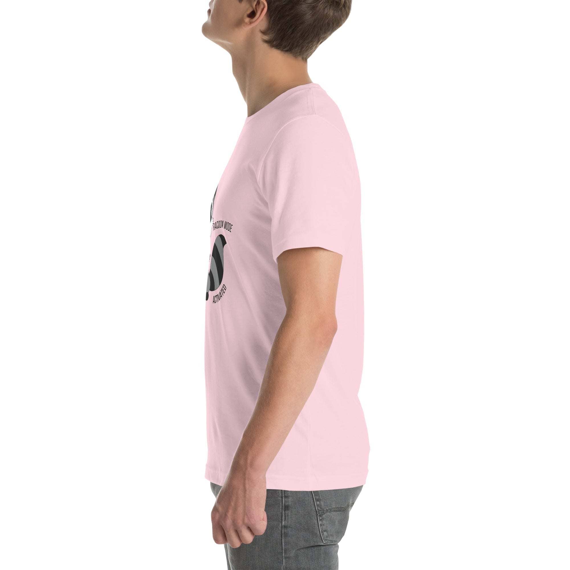 Side view of man wearing light pink Raccoon Mode T-Shirt with cartoon raccoon design and text on front