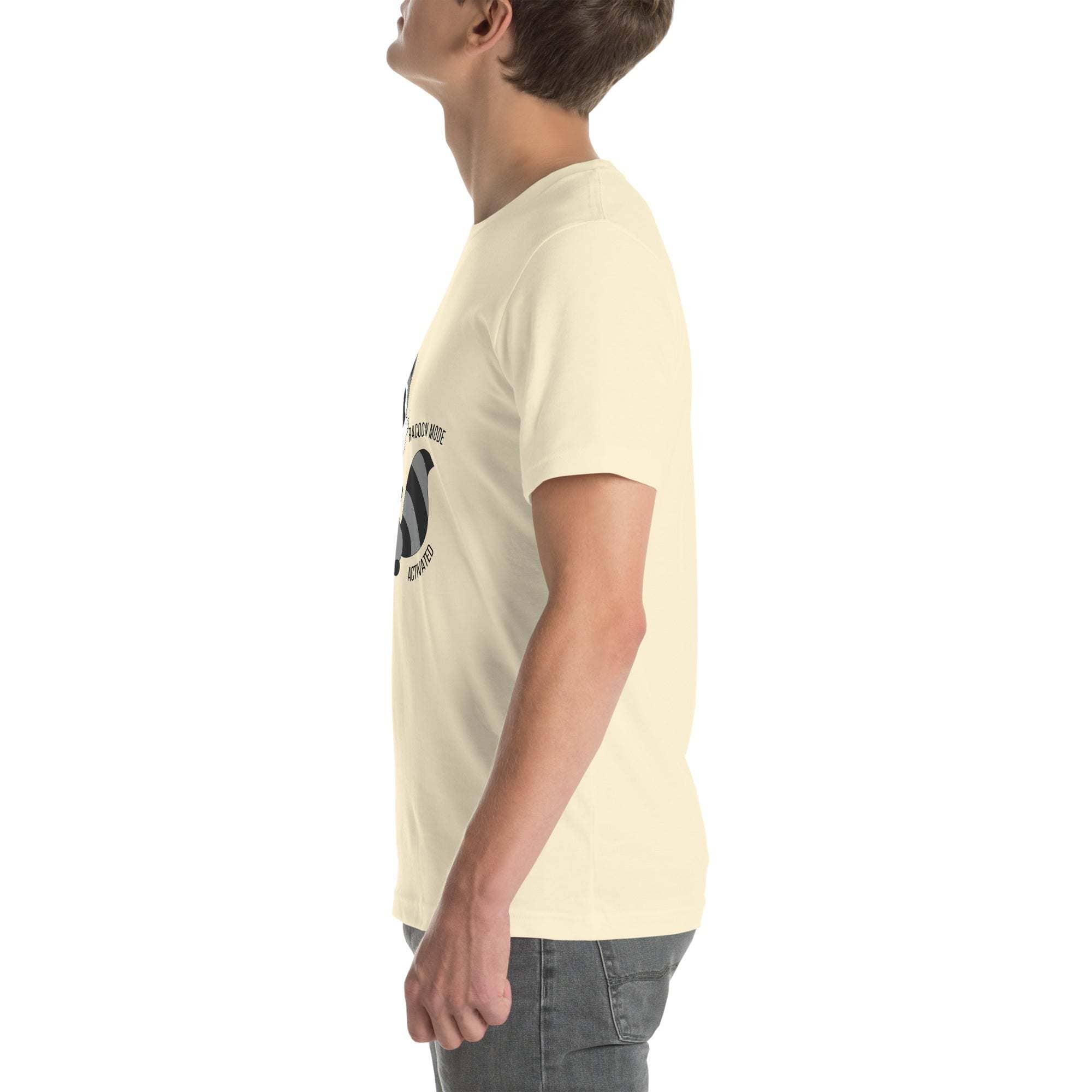 Side view of a person wearing a beige Raccoon Mode T-Shirt with cartoon raccoon design and text.