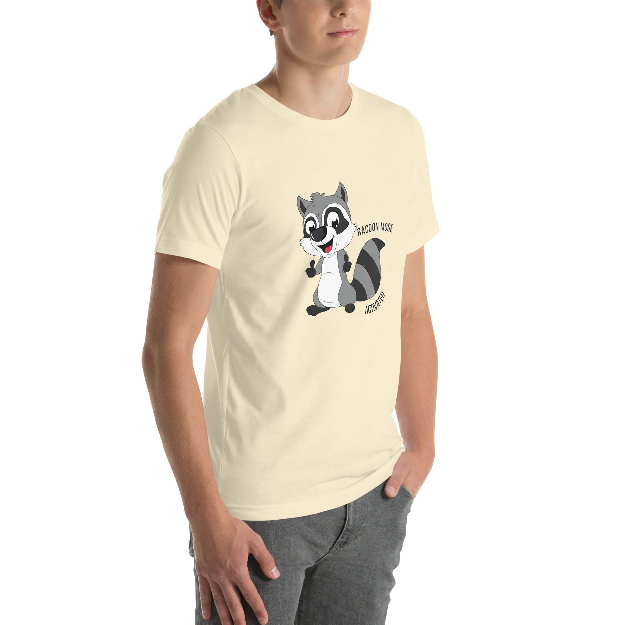 Man wearing a soft cotton cream Raccoon Mode T-Shirt with a cute cartoon raccoon and "Raccoon Mode Activated" text on front