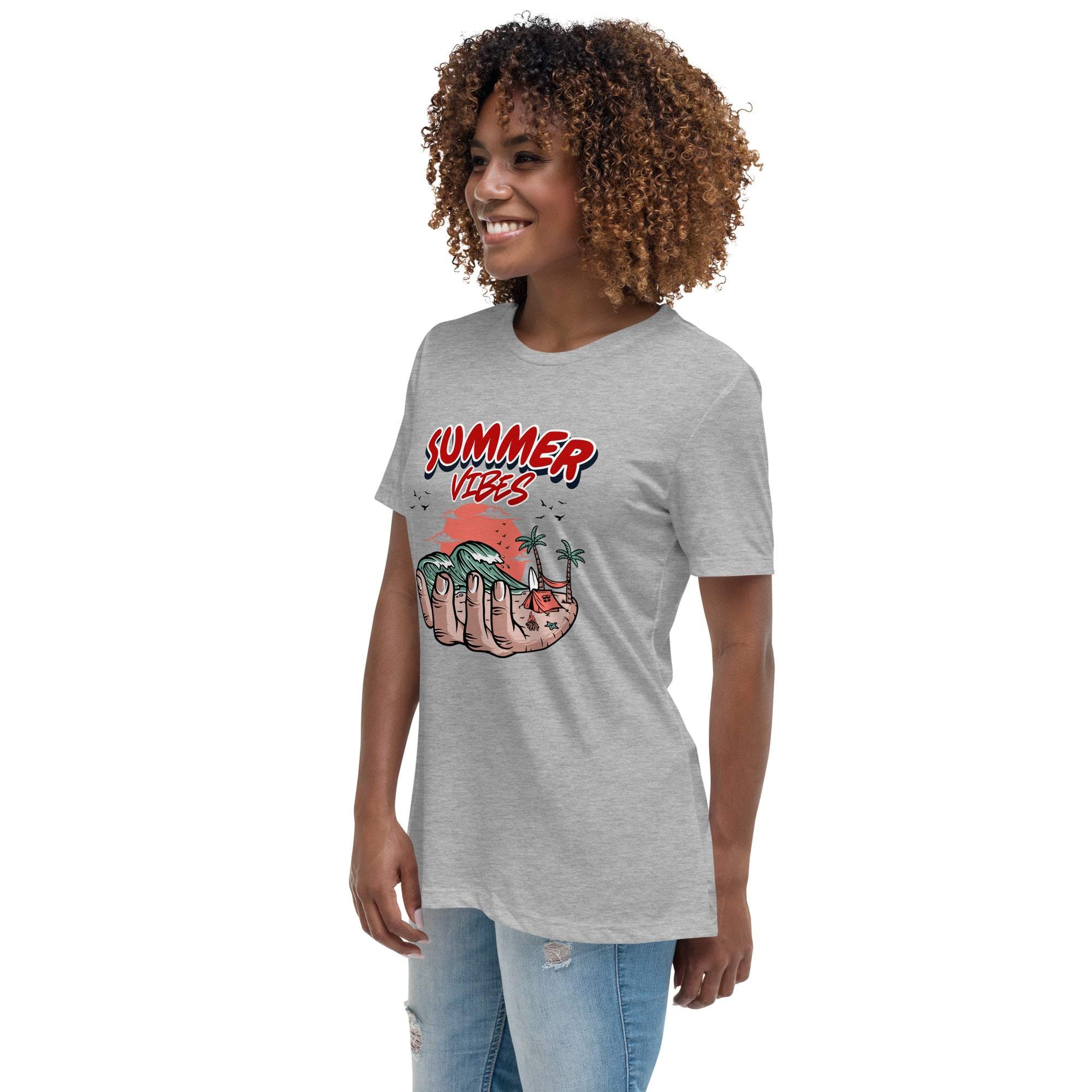 Woman wearing a gray Summer Vibes T-Shirt with a retro beach graphic showing a hand holding waves, palm trees, and a sunset.