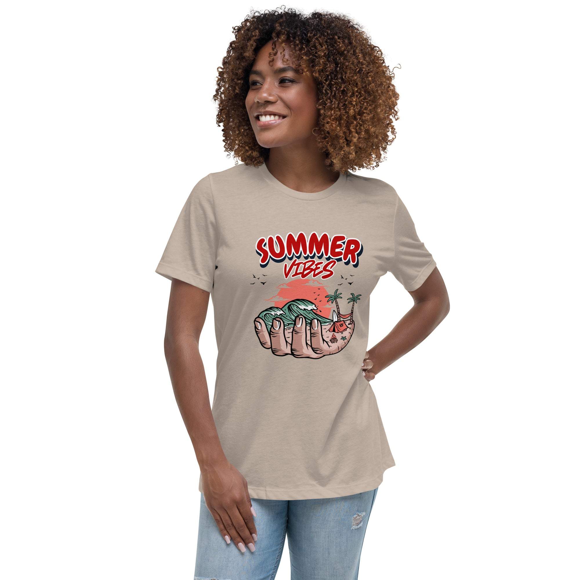 Woman wearing beige Summer Vibes T-Shirt with retro beach graphic held in hand and red text, paired with light blue jeans.