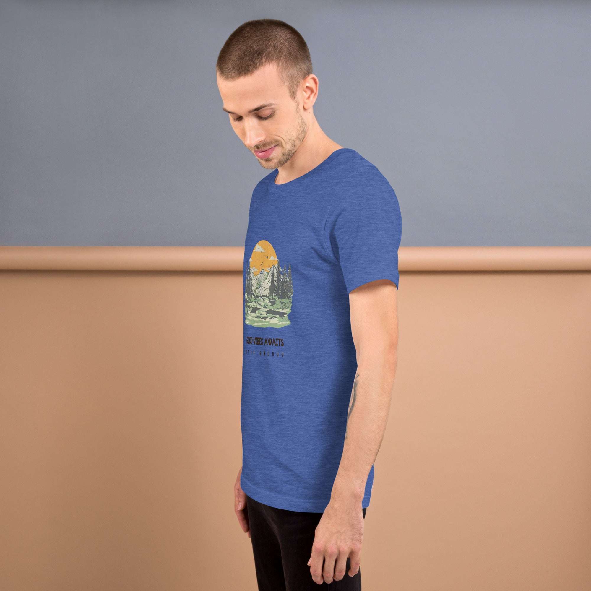 Man wearing blue Good Vibes T-shirt with nature graphic and sunset design