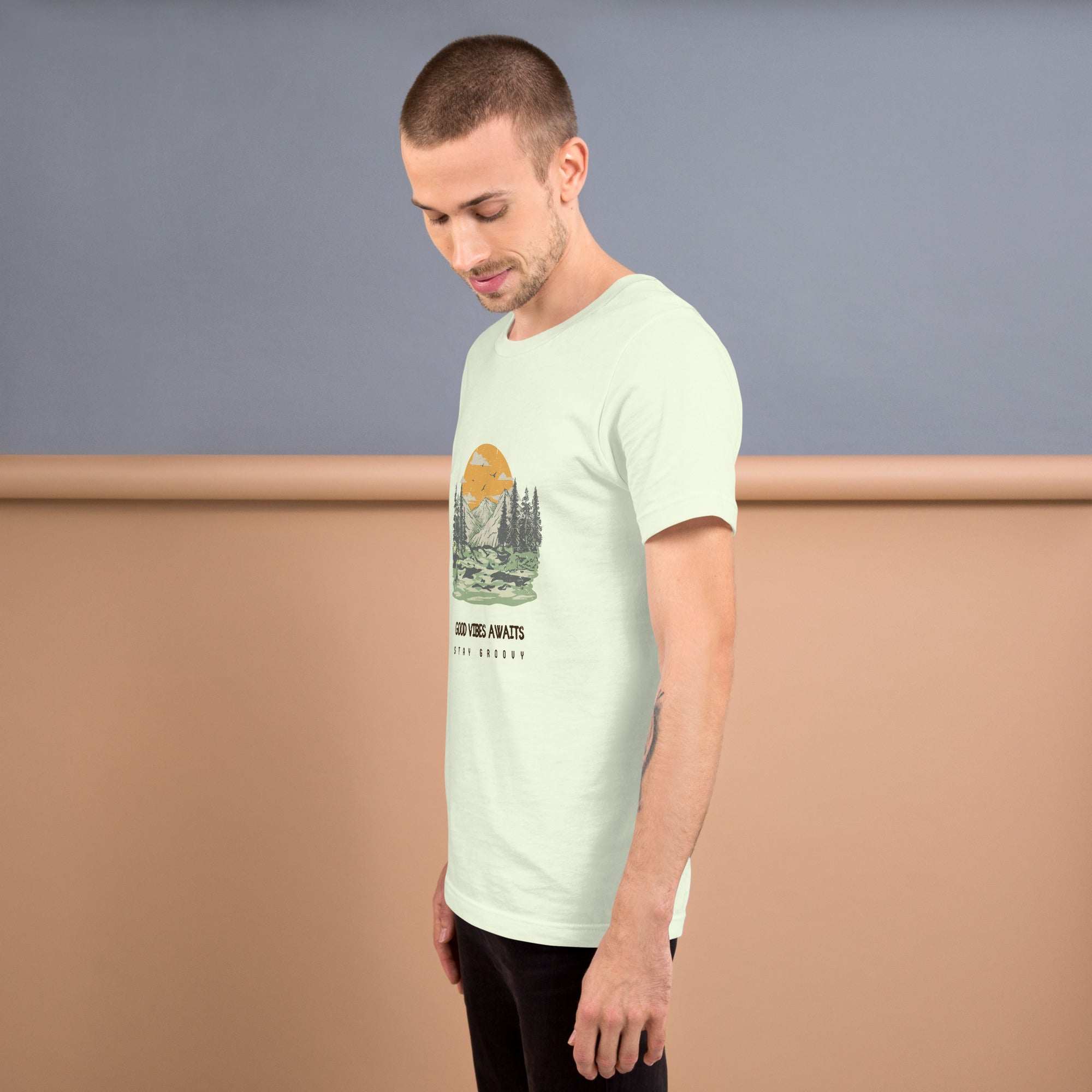 man wearing soft lightweight Good Vibes T-Shirt with nature graphic on light background