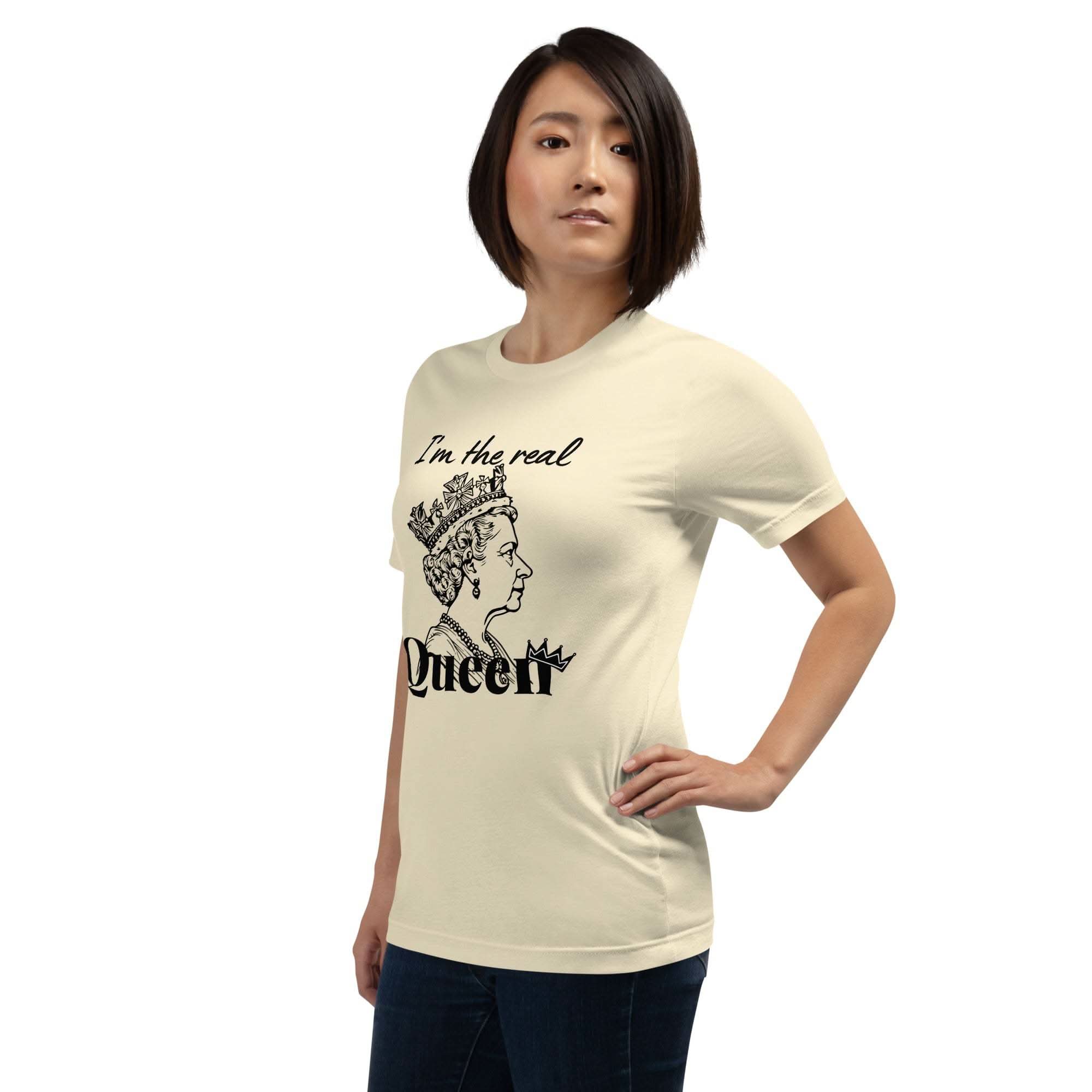 Woman wearing beige "I'm the Real Queen" T-shirt with queen crown graphic and bold text, styled casually