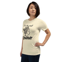 Woman wearing beige "I'm the Real Queen" T-shirt with queen crown graphic and bold text, styled casually
