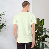 Back view of man wearing plain light green vintage aesthetic frog and mushroom t-shirt surrounded by plants