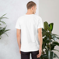 Back view of man wearing plain white Frog and Mushroom T-Shirt standing near green plants