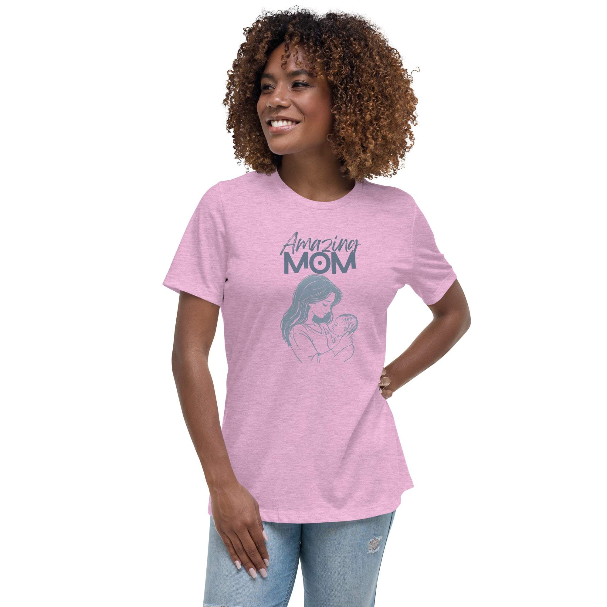 Woman wearing a pink "Amazing Mom" t-shirt with a mother holding a baby graphic, paired with jeans, smiling and posing confidently