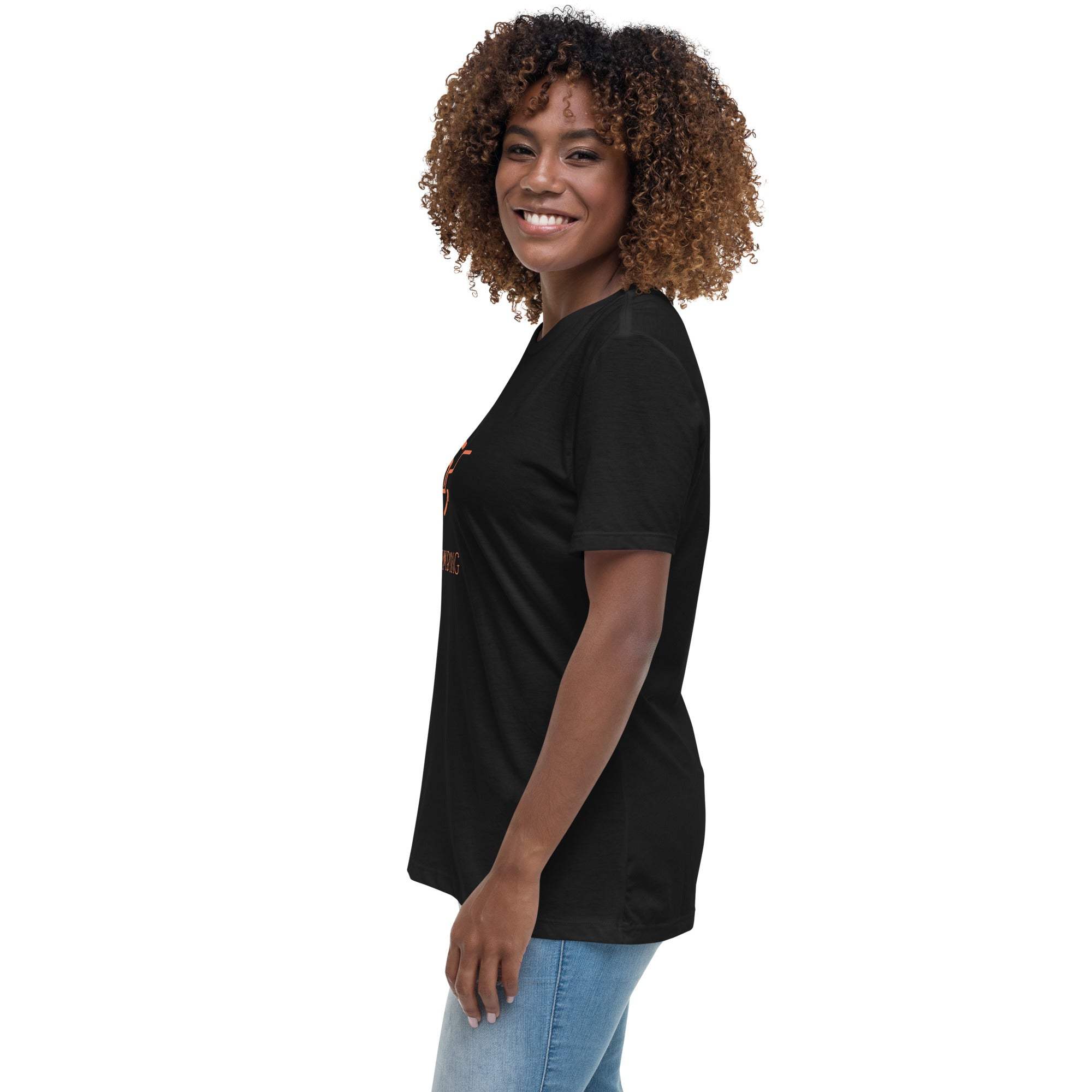 Side view of a woman wearing a black "Keep Climbing" women's t-shirt with short sleeves and a relaxed fit paired with blue jeans