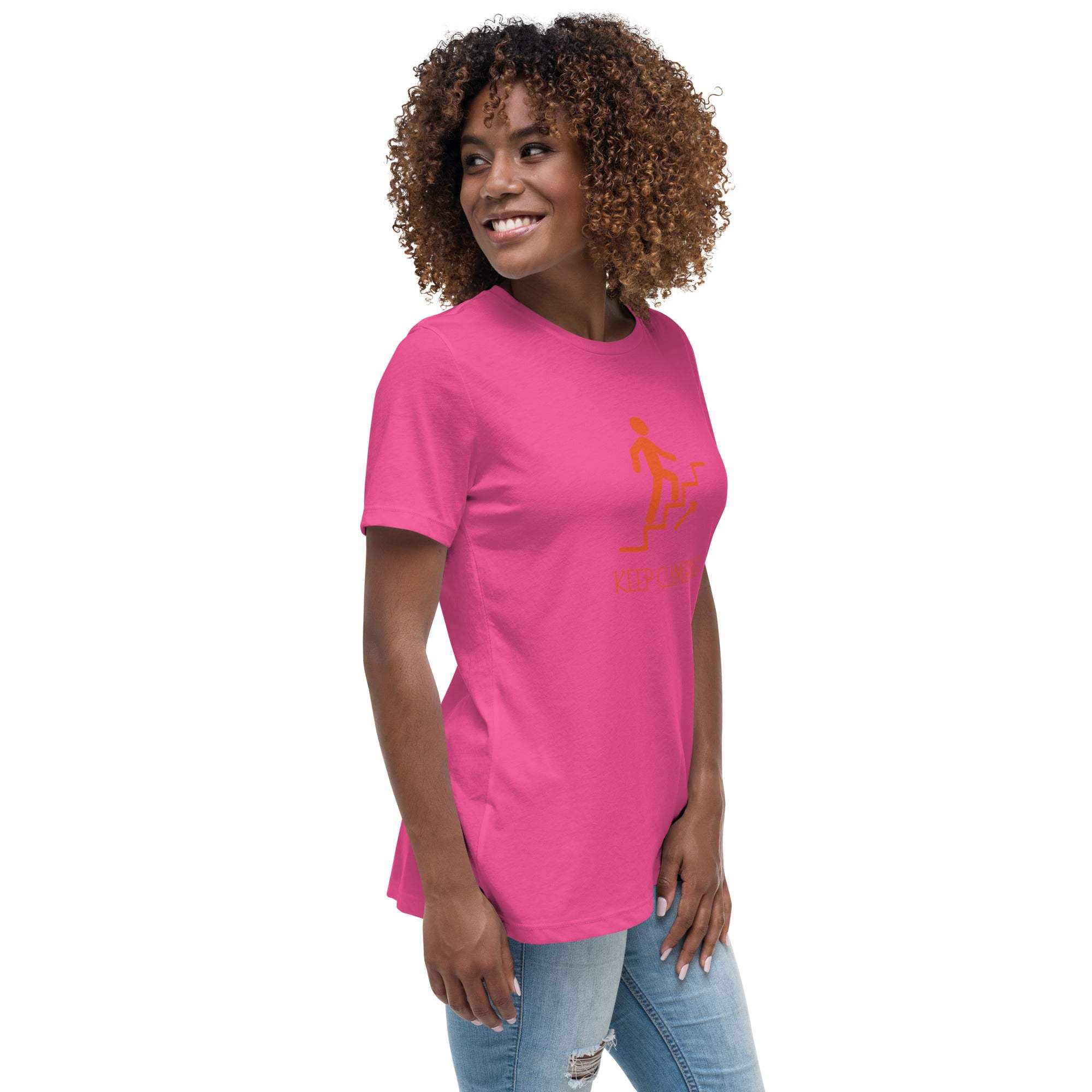 Woman wearing bright pink Keep Climbing women's t-shirt with motivational graphic, styled casually with jeans