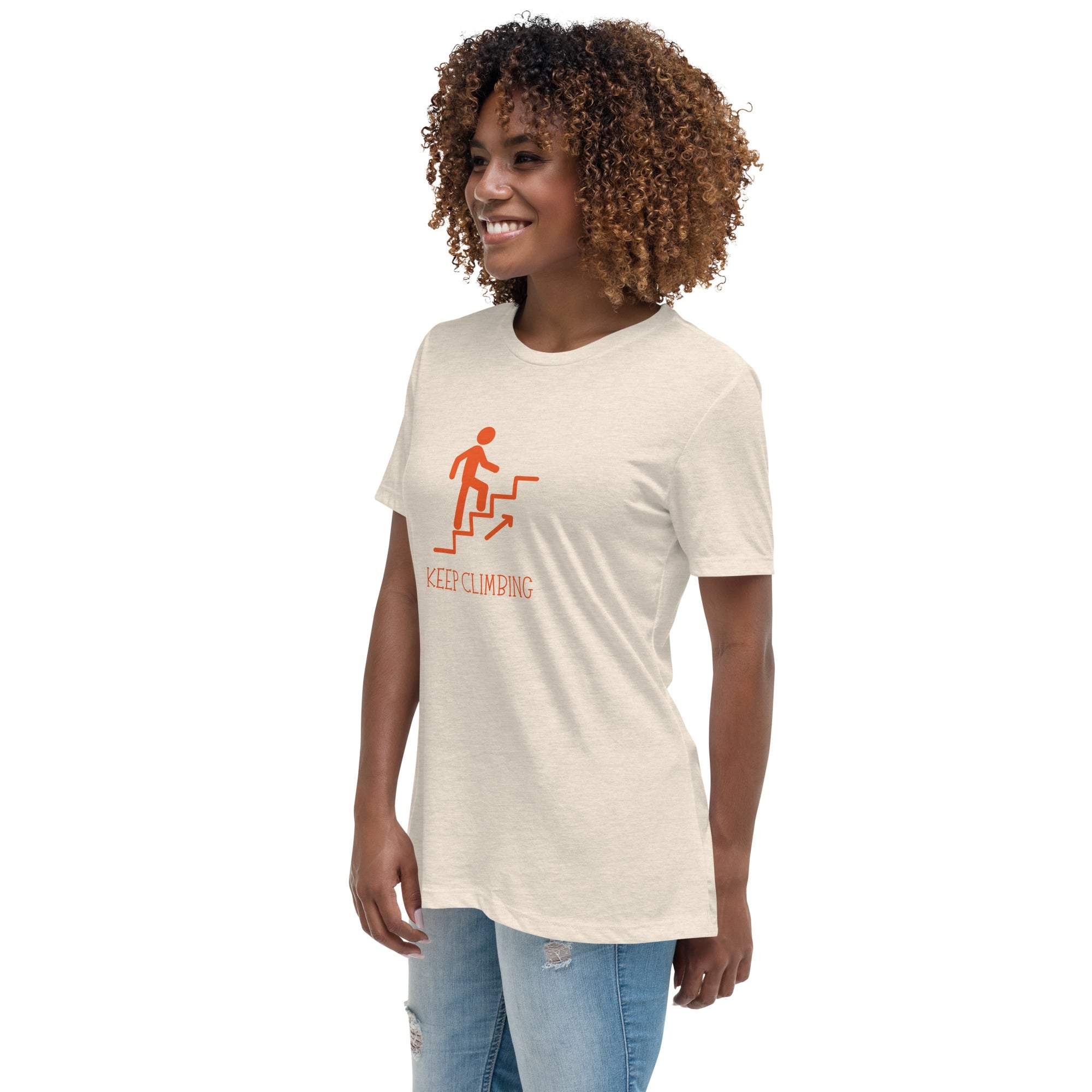 Woman wearing a beige "Keep Climbing" motivational graphic t-shirt with jeans