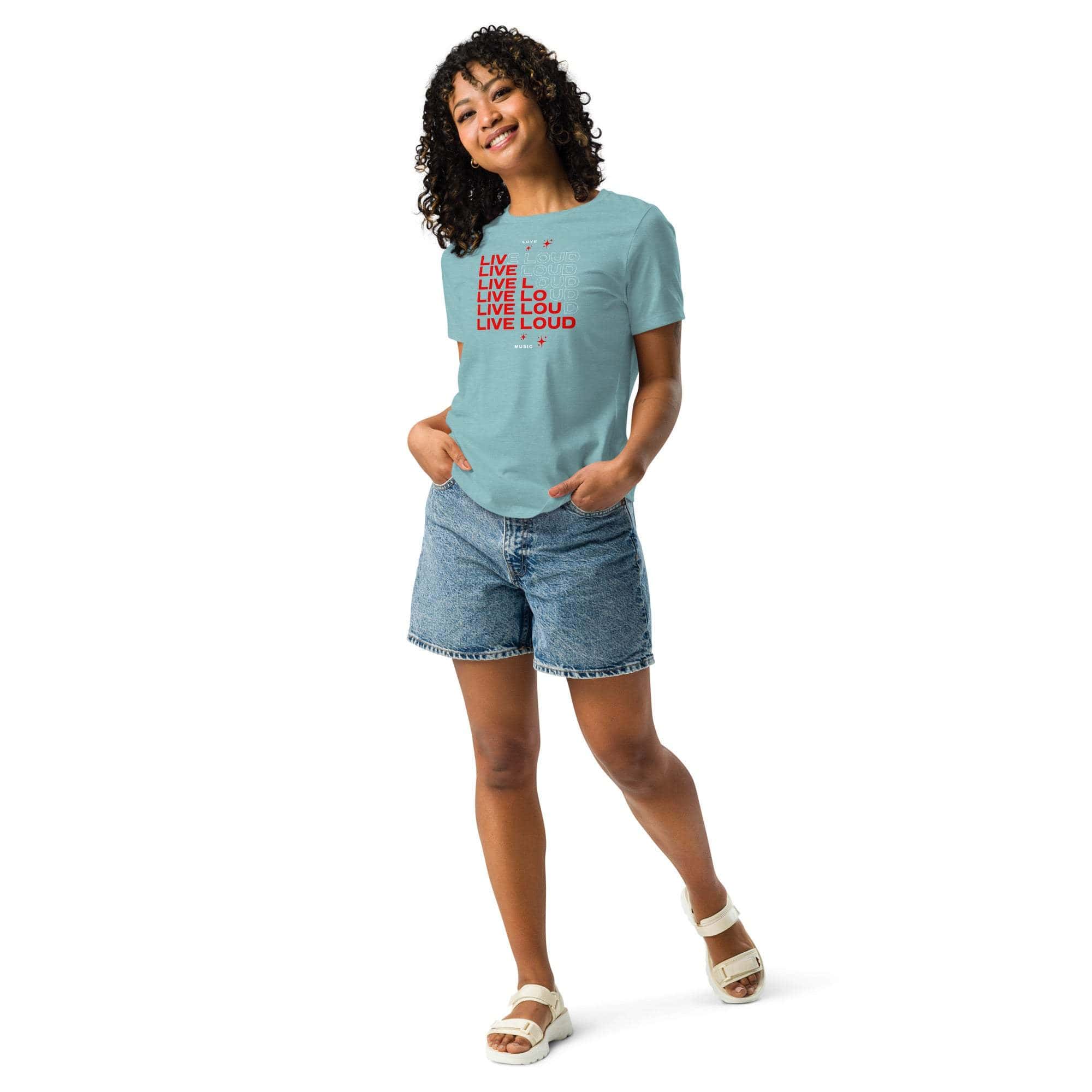 Woman wearing a light blue LIVE LOUD Music T-Shirt with bold red retro typography paired with denim shorts and white sandals