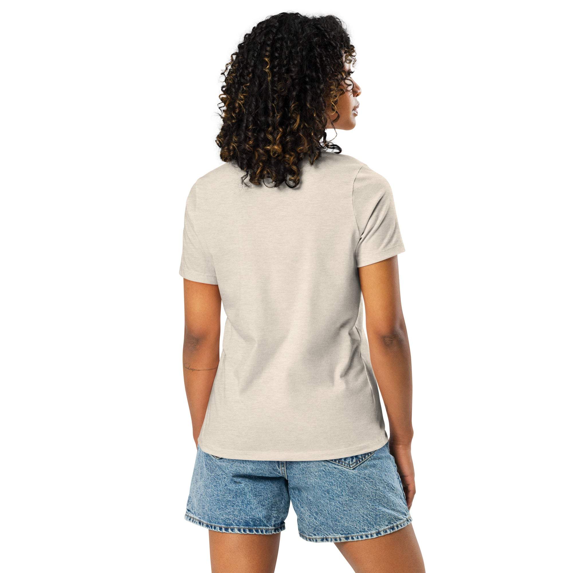 Woman wearing beige "I'm Not Lazy, I Am On Energy Saving Mode" sloth t-shirt with denim shorts, back view
