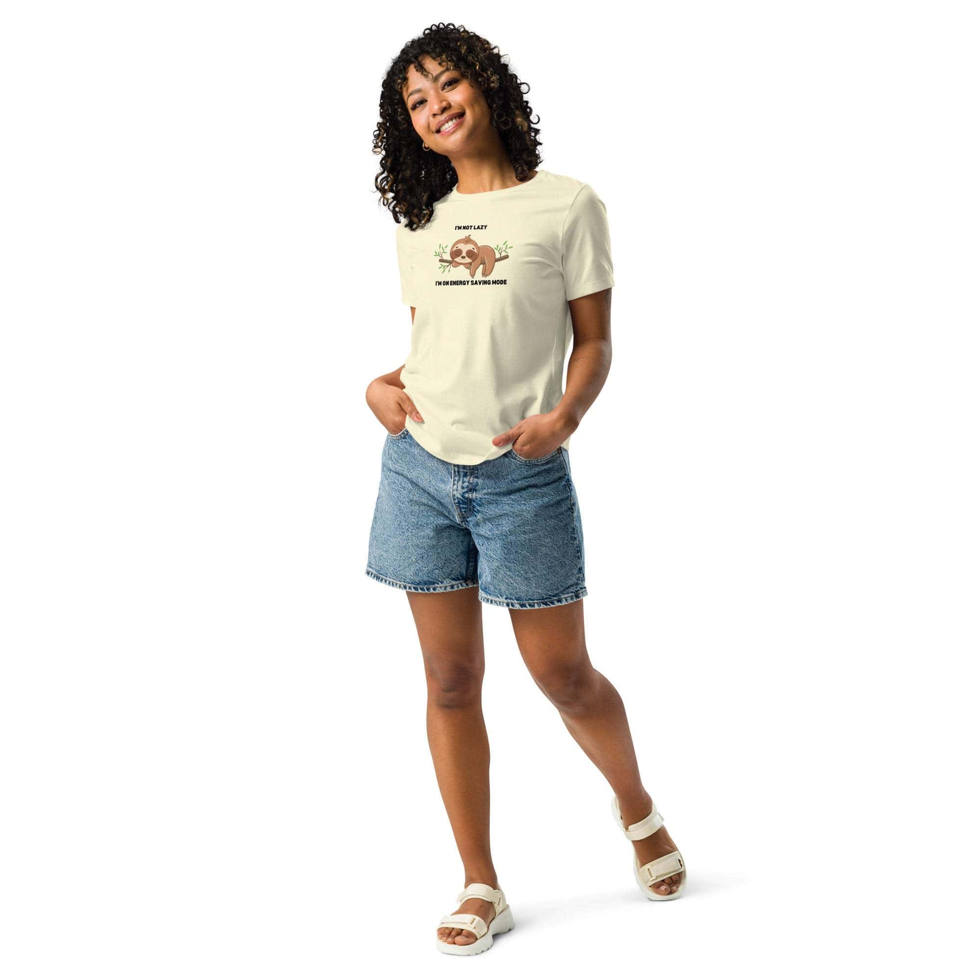 Woman wearing a cream sloth T-shirt with "I'm Not Lazy, I Am On Energy Saving Mode" text and denim shorts