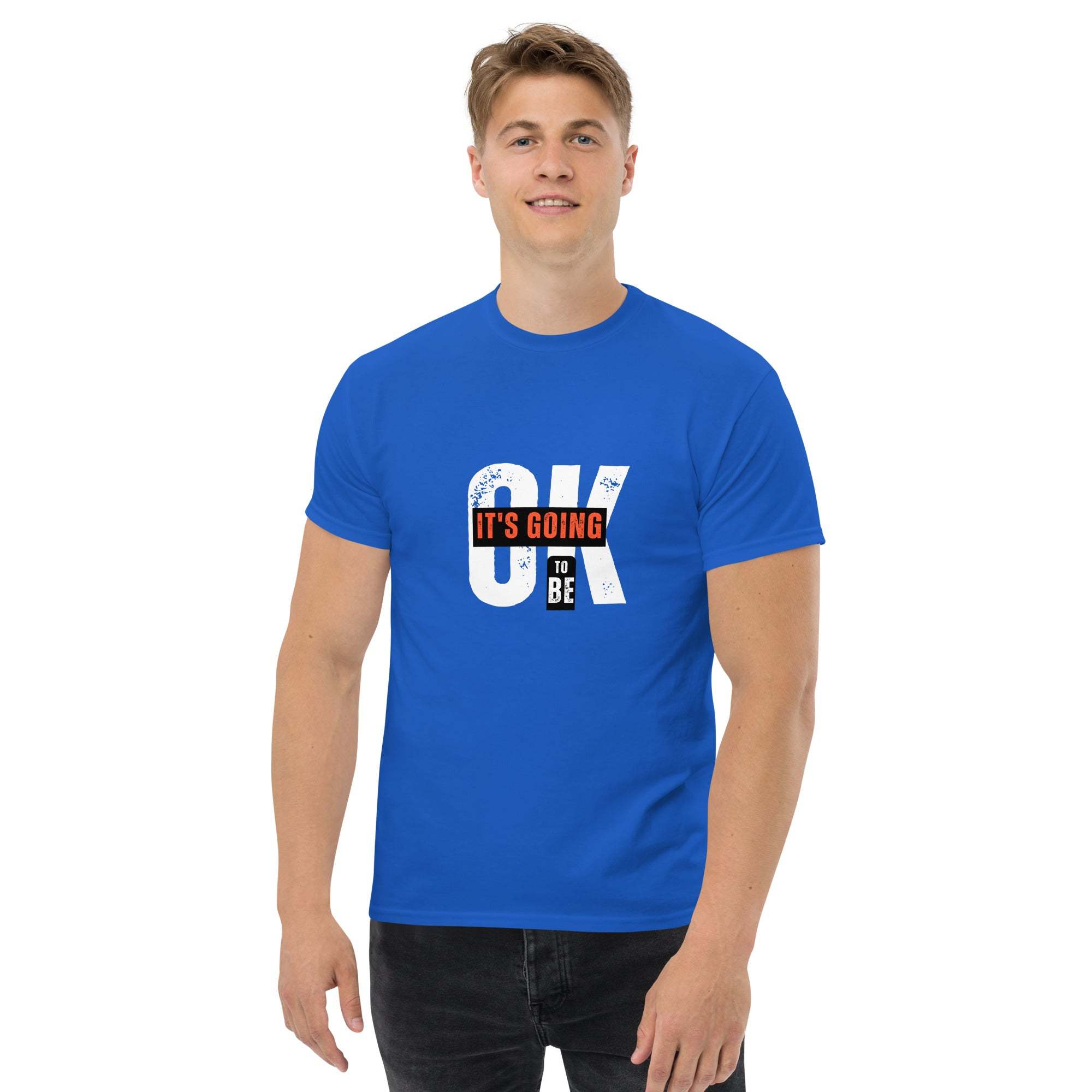 Man wearing blue trendy graphic t-shirt with motivational quote "It’s going to be OK" on front