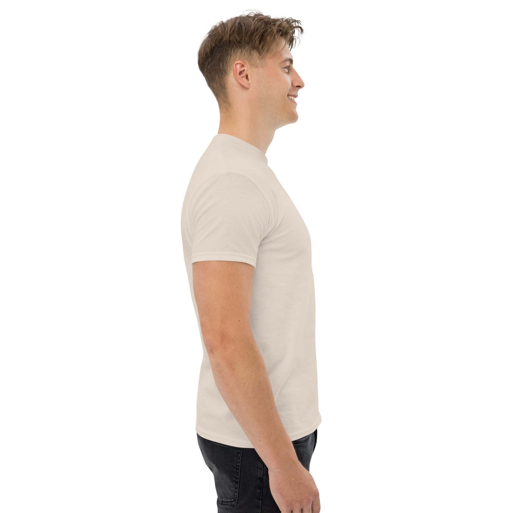 side view of man wearing beige trendy graphic t-shirt and dark jeans