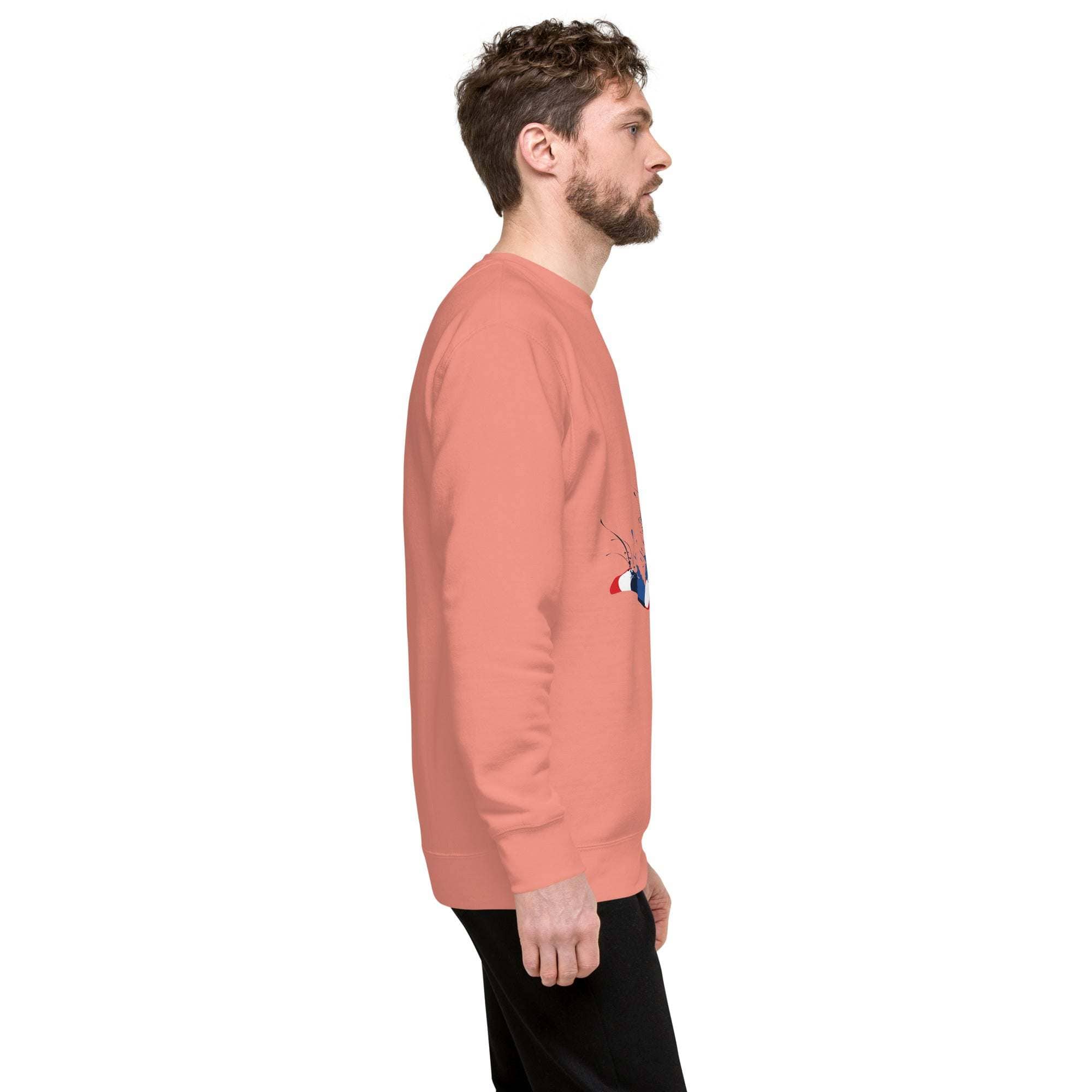 Side view of a man wearing a coral Soccer Player Sweatshirt with a sports graphic and black pants