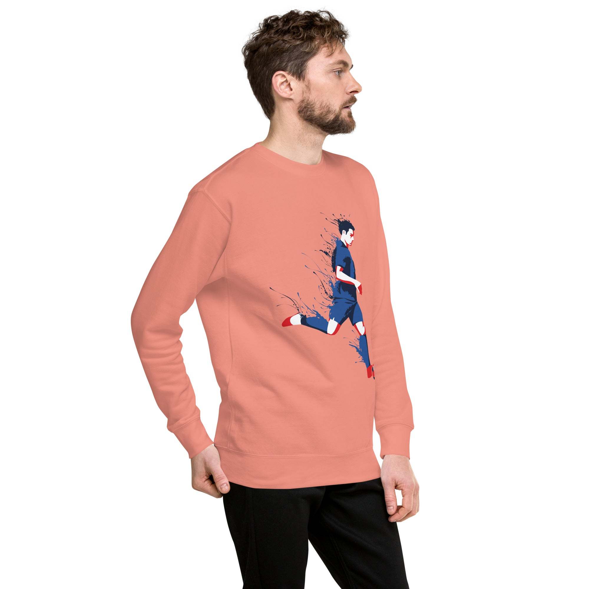 Man wearing coral soccer player sweatshirt with dynamic sports graphic and black pants